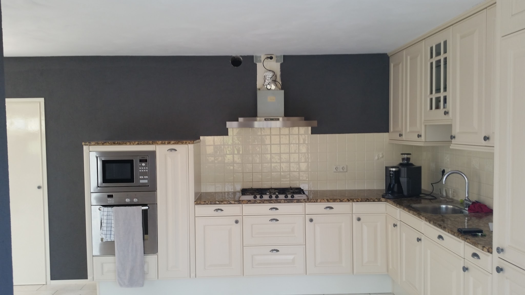 Keuken met een donkergrijze gestructureerde muur boven de kastjes